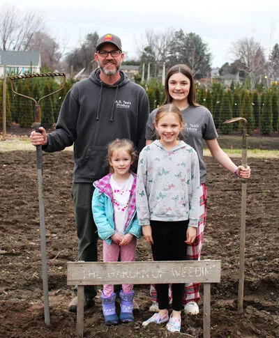Family gardening moment with kids, showcasing joyful outdoor bonding and playful attitudes in a garden.